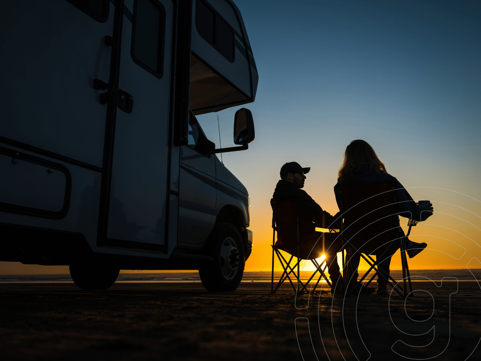 Wohnwagen mit Paar in Klappstühlen beim Sonnenuntergang – romantisches Camping, Vanlife und Outdoor Urlaub in der Natur.